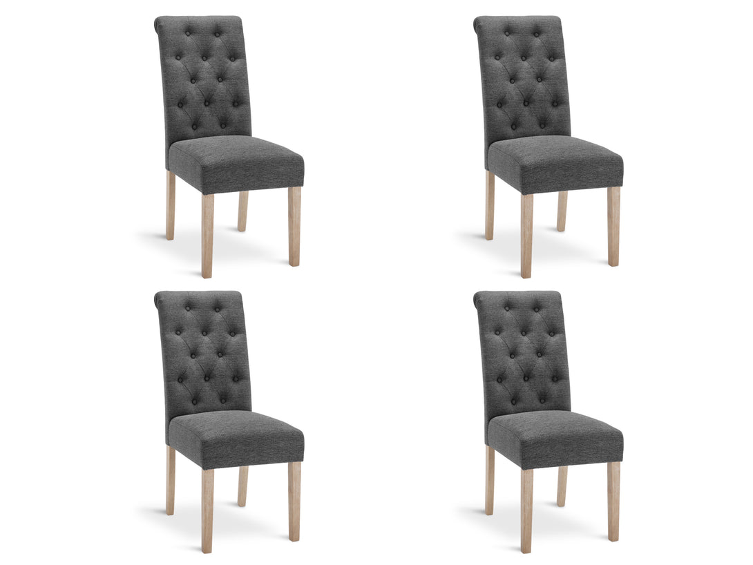 Four Zoey upholstered dining chairs in dark grey with button backrest and wooden legs.