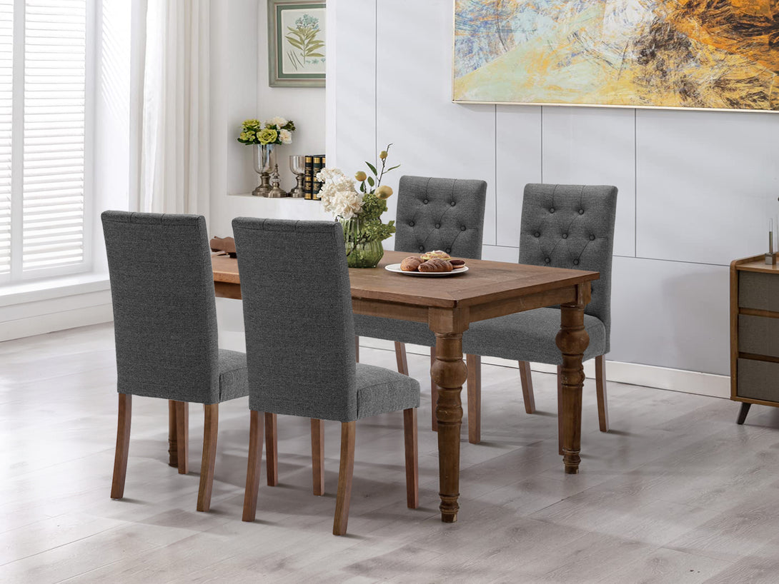 Lucia 4 Piece Upholstered Dining Chair set in Dark Grey with button tufted backrests around a wooden dining table.