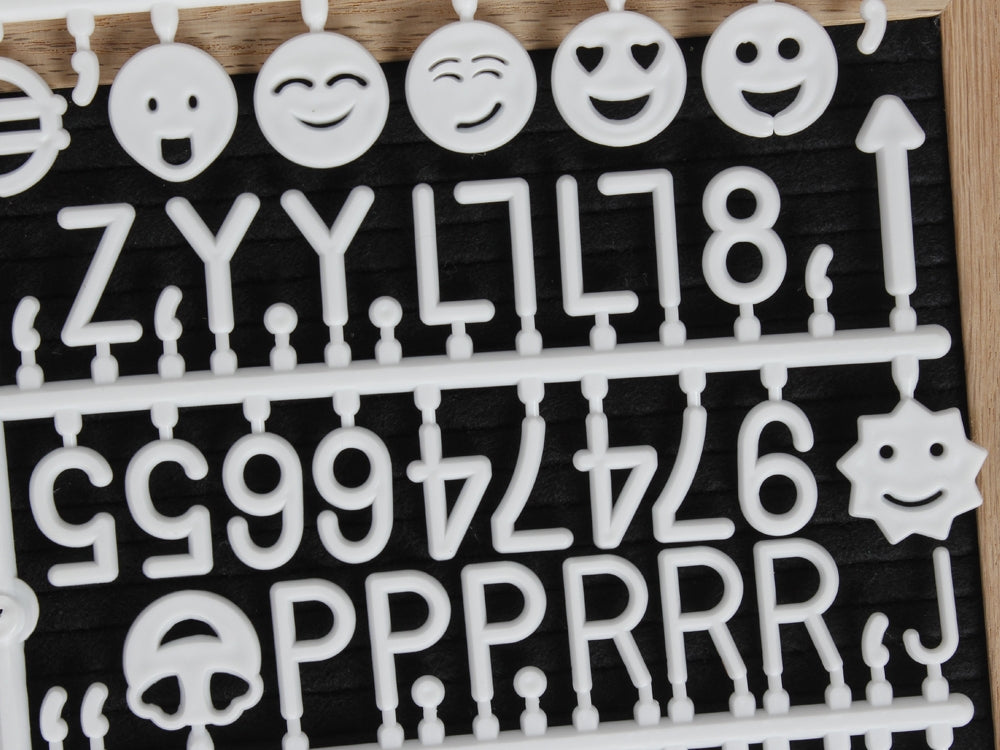 Close-up of white letters and emojis for a DIY felt letter board, perfect for creative quotes and milestones.