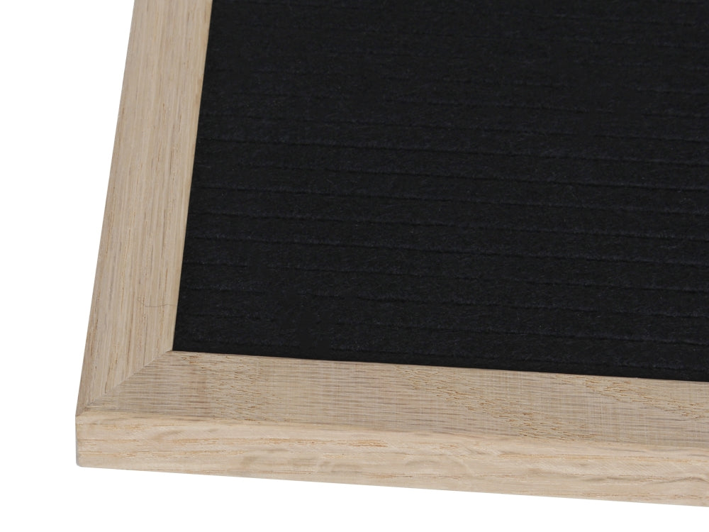 Close-up of a retro changeable DIY felt letter board with a wooden frame and black felt surface.