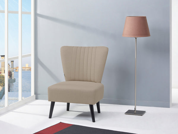 Anita Occasional Chair in beige fabric, elegant design, paired with modern floor lamp in bright room with large windows.