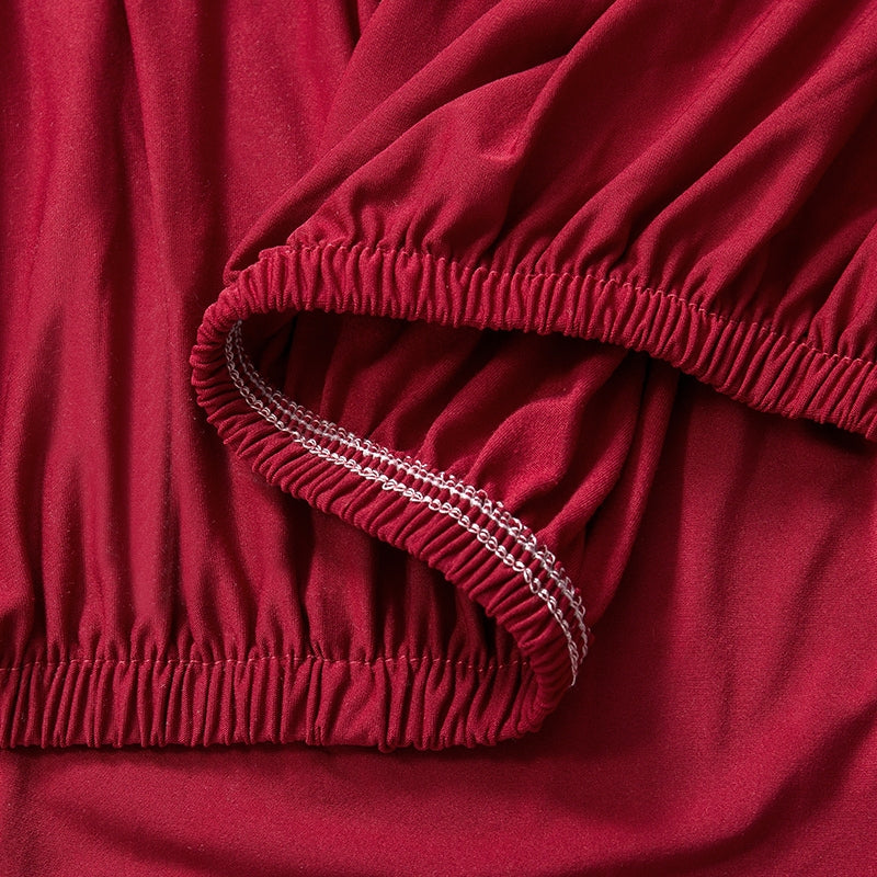 Close-up of the elastic hem of a red 2 seater sofa couch cover, showcasing its durable and stretchy fabric.